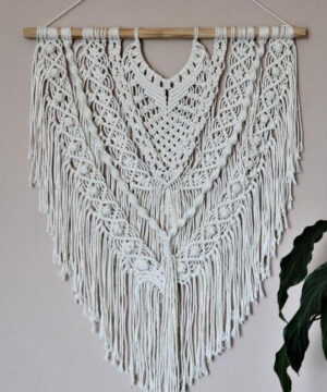 makrama na ścianę w kolorze ecru zawieszona na drewnianym kołku